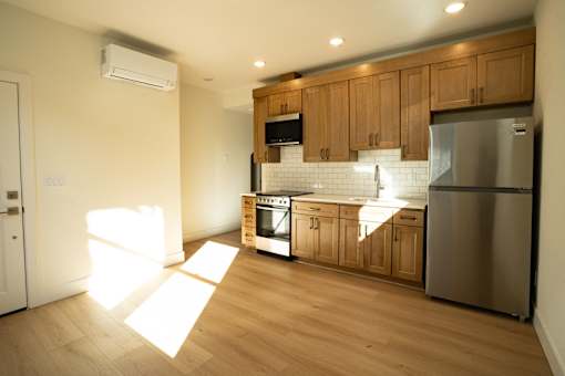 A kitchen with wooden cabinets and a stainless steel refrigerator.