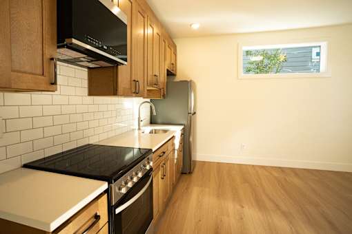 A kitchen with wooden cabinets and a black stove top.