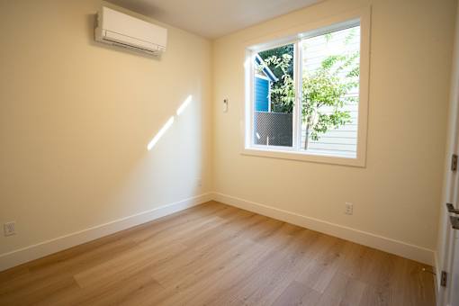 A room with a window and wooden flooring.