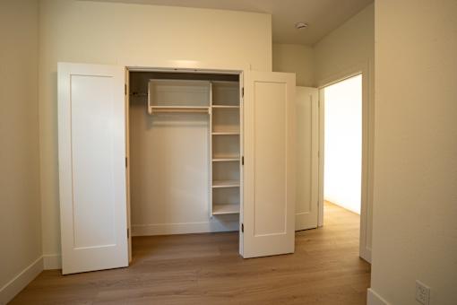 A white door is open to a room with a shelving unit.
