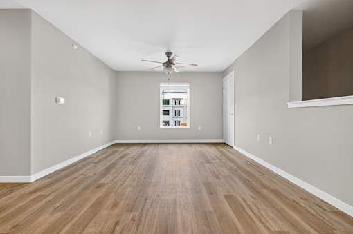 A room with a ceiling fan and a cabinet with drawers.