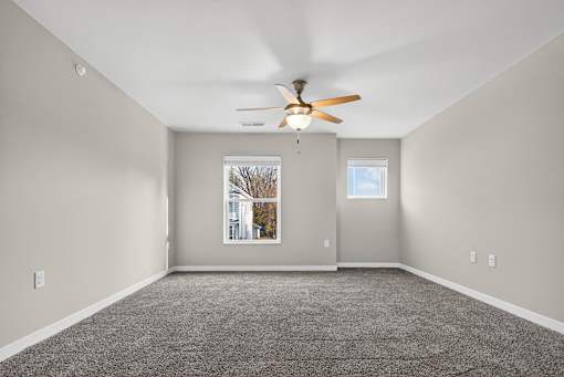 A room with a ceiling fan and a window.