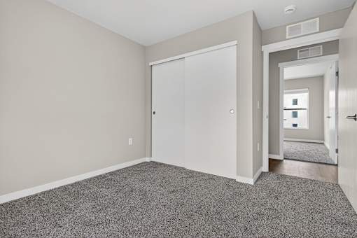 A room with a grey carpet and a white door.