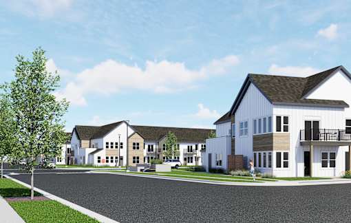 A row of houses with a person walking in front of the first house at The Daniels at Northern Gateway Apartments, Saukville 53080