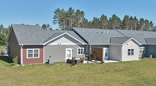 A house with a door is surrounded by other houses and trees.