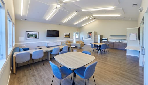 A conference room with a long table surrounded by chairs.