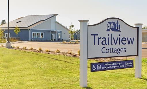 A sign for Trailview Cottages in front of a building.