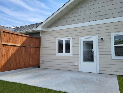 A house with a brown fence and a white door.