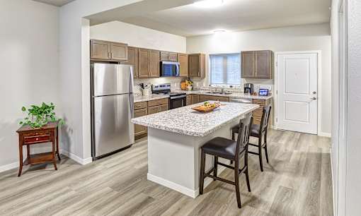 A kitchen with a table and chairs in the middle of the room.