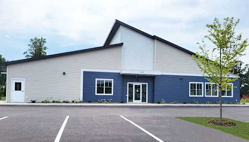 A blue and beige building with a white door and windows.