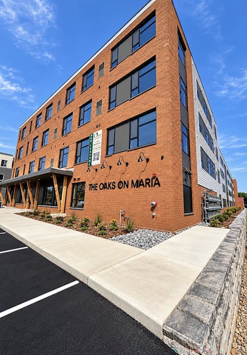 The Oaks on Maria is a brick building with a parking lot in front.