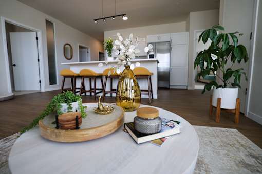 A dining table with a vase of flowers and a book on it.