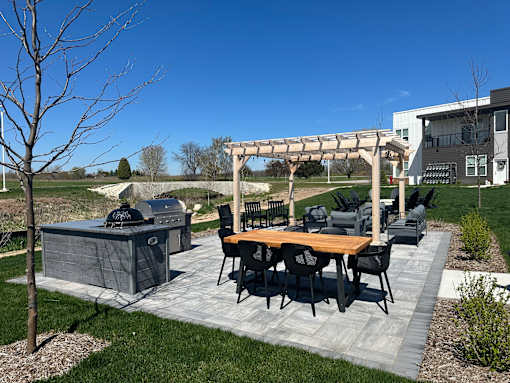 A patio with a table and chairs under a pergola.