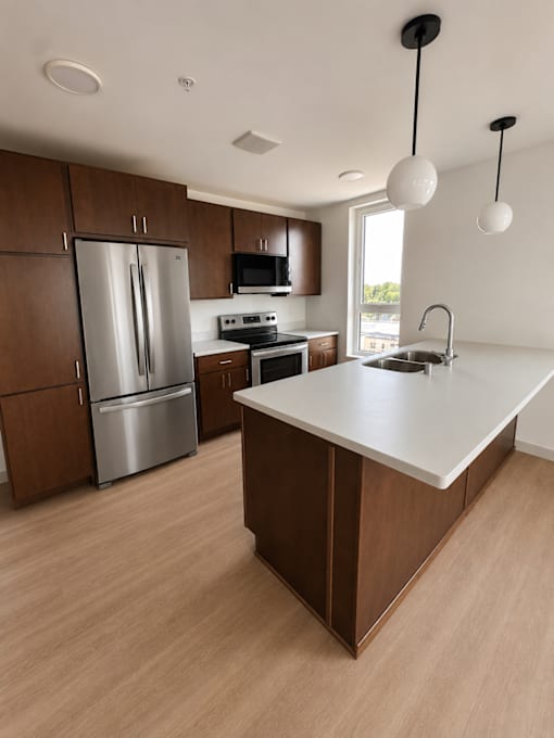 A kitchen with a counter top and wooden cabinets.