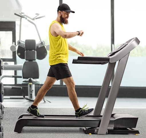 A man on a treadmill in a gym.