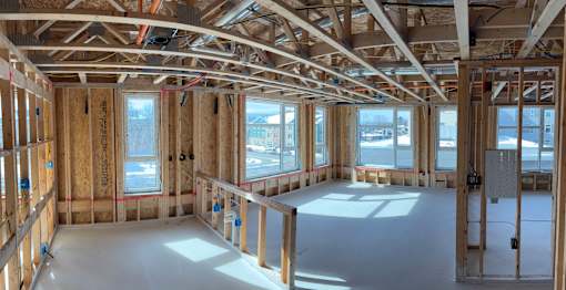 A room under construction with wooden beams and unfinished walls.
