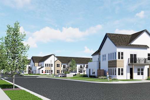 A row of houses with a person walking in front of the last one.