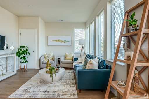 A living room with a blue couch and a white coffee table.