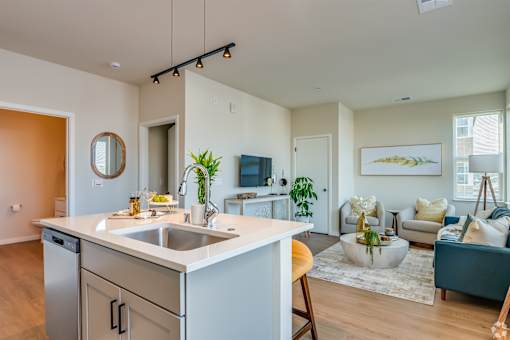 A modern kitchen with a white countertop and a sink.