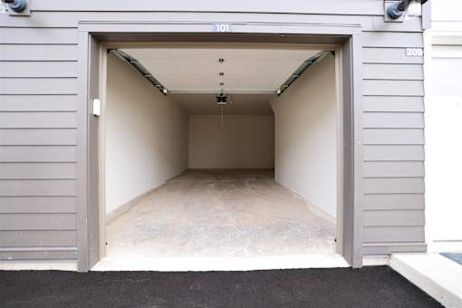 A garage door is open to reveal a clean, empty garage inside.