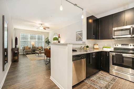 A modern kitchen with black cabinets and stainless steel appliances.