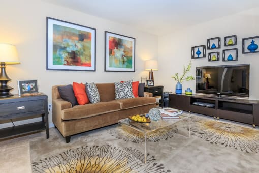 a living room with a brown couch and colorful pillows