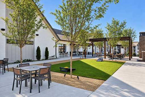A patio with a table and chairs is surrounded by trees.