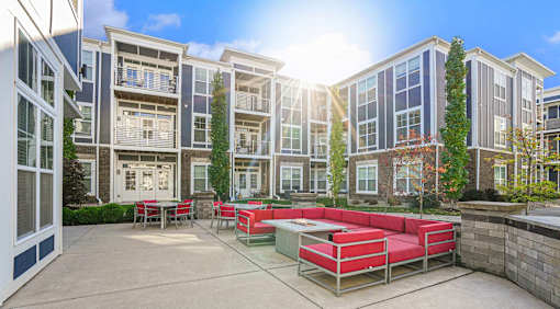A sunny day at a modern apartment complex with a red seating area.