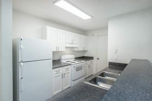 A kitchen with white appliances and cabinets.