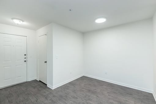 A room with a white door and a grey floor.