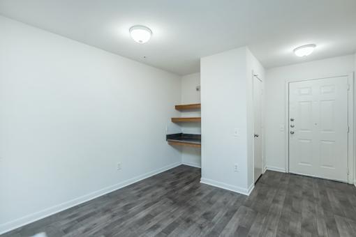 A room with a white door and a grey floor.