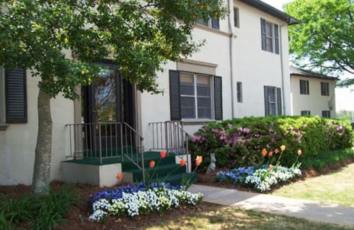 a white house with black shutters and a tree in front of it at Avondale Station Apartments, Georgia