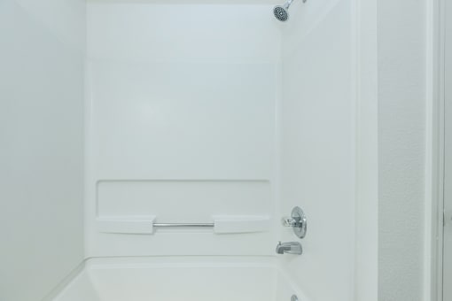 A white bathroom with a shower and a door.