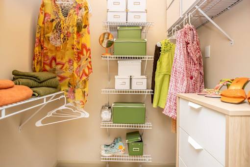 A closet with clothes and a dresser.