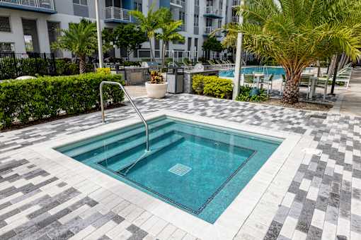 A small pool surrounded by a black and white tiled floor.