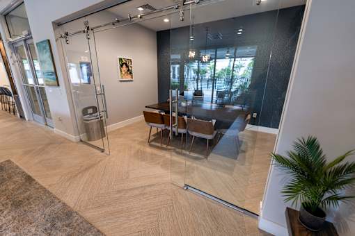 A glass door separates a living room from a dining room.