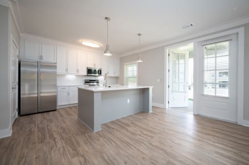 a kitchen with white cabinets and a large island