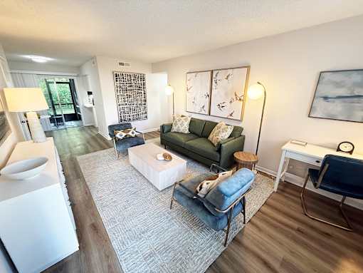 A living room with a green couch and a white coffee table.