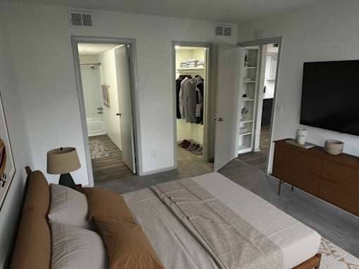 A bedroom with a large bed and a flat screen TV.
