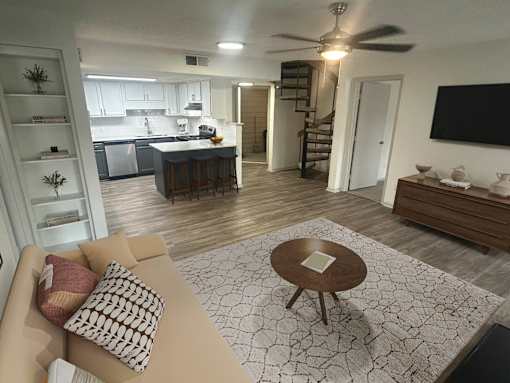 A living room with a couch, coffee table, and a kitchen in the background.