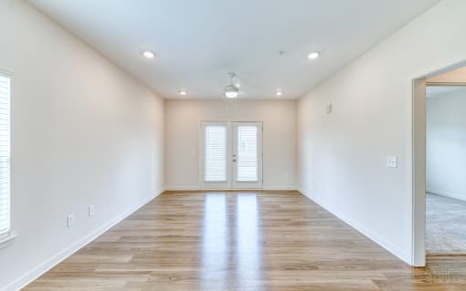 an empty living room with white walls and wood floors