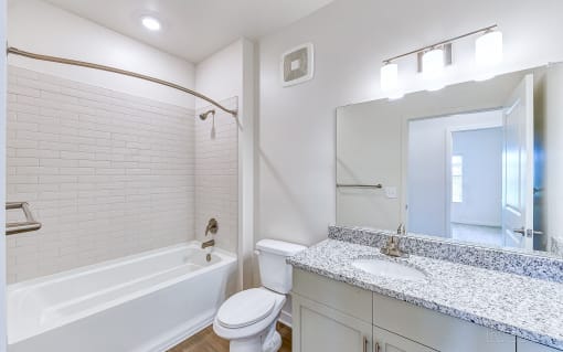 a bathroom with a sink toilet and tub and a mirror