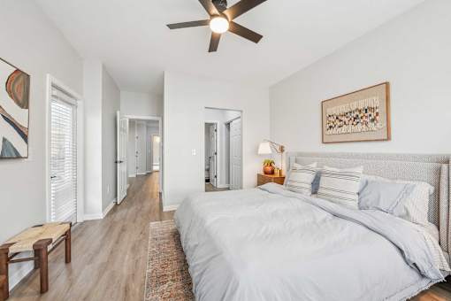 A bedroom with a large bed and a ceiling fan.