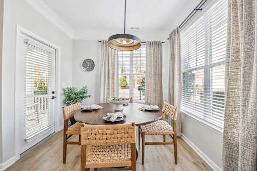 A dining room with a table set for two and a view of the backyard.