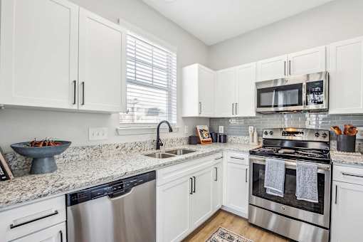 A kitchen with white cabinets and stainless steel appliances.