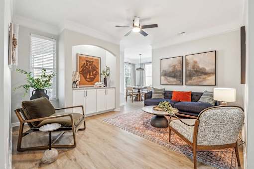 A living room with a chair, a sofa, and a table.
