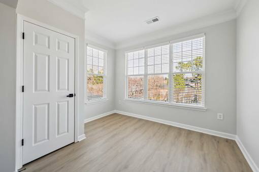 A room with a white door and a window with blinds.