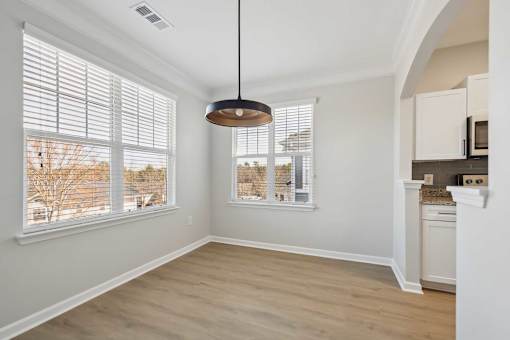 A room with a large window and a hanging light fixture.