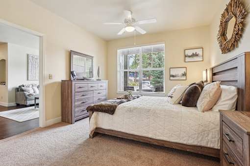 A bedroom with a bed, dresser, and mirror.