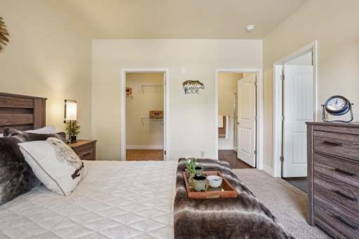 A bedroom with a large bed and a tray with plants and a bowl on it.